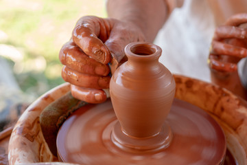 Fototapeta na wymiar The master's hands make a pot on the potter's wheel.