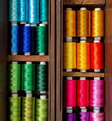 Close up picture of spool of colorful threads in the old wooden box