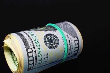 Roll of US dollars in rubber.