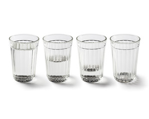 Faceted glass with and without clear liquid (vodka or water), isolated on white background