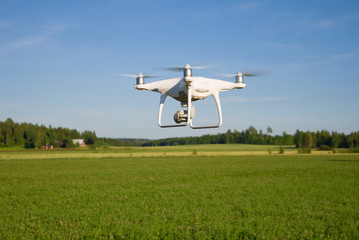 The quadcopter flying over the field close-up