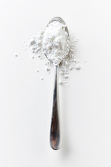Obraz na płótnie Canvas Spoon full of powder sugar on white, from above