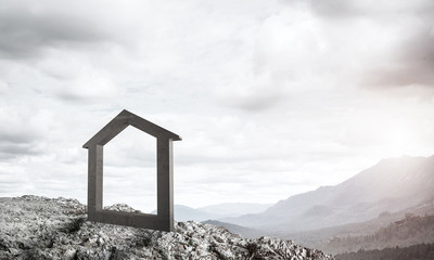 Conceptual image of concrete home sign on hill and natural lands