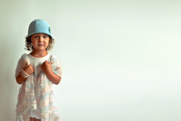 Glamorous girl. Children's fashion. Girl in blue cap on a white background.