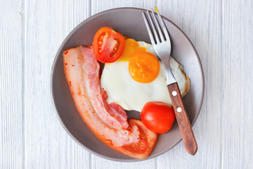 White wooden table with pork bacon and fried egg lunch