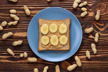 Peanut butter toast with banana slices  on wooden background