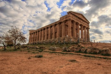 Fototapeta na wymiar Griechischer Concordiatempel mit Wolken in Agrigent auf Sizilien
