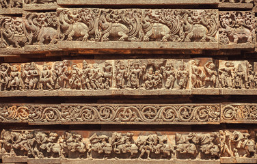 Facade of Indian temple with friezes narrating legends from the Hindu texts. Animals, people and patterns from 12th century, Halebidu, India