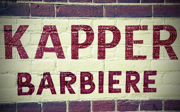 barber shop sign written in Dutch and Italian