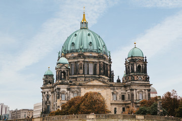 Fototapeta na wymiar The Berlin Cathedral is called Berliner Dom against the blue sky. Beautiful old building in the style of neoclassicism and baroque with cross and sculptures. Berlin, Germany