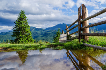 old wooden fence against the background of mountains, fences in the water