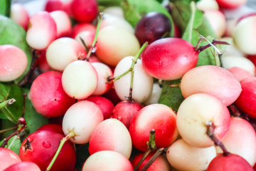 Carunda or Karonda fruit and green leaves background
