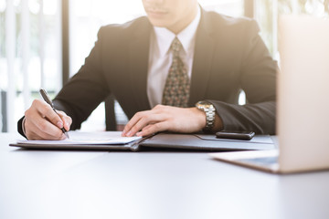 Asian Business man working at office with laptop and documents on his desk, consultant lawyer concept