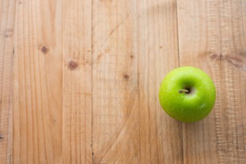 Green apple on wooden table. selective focus.