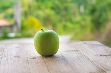 Green apple on wooden table. selective focus.