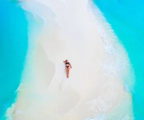 Fotobehang Beautiful woman tans on sandbank surrounded by turquoise ocean from above © nakedking