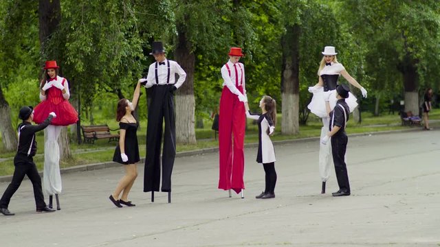 Mimes dance with stilts at the street