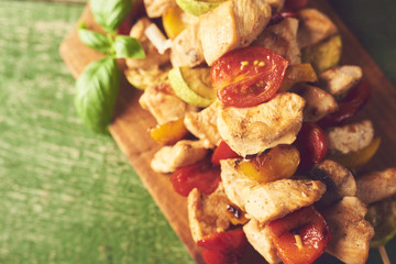 Bbq chicken breast with vegetables on wooden skewers on cutting board with spices
