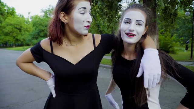 Girls mimes imitate arguing at the street
