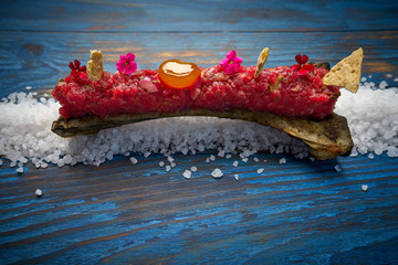 Steak tartar with egg yolk on half bone