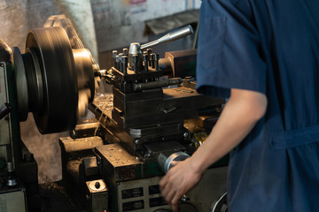 Professional machinist : man operating lathe grinding machine - metalworking industry...