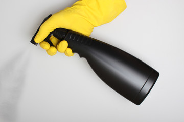 hand yellow glove and black bottle sprayer