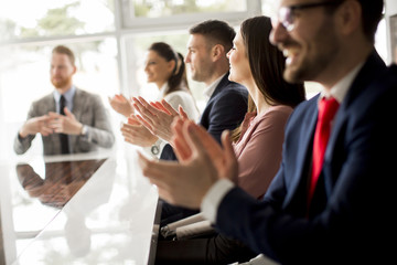 Businesspeople applauding while in a meeting at office