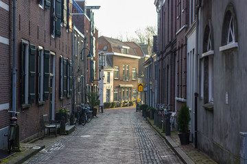 Gouda, South Holland/The Netherlands - March 31 2018: early morning sunrise in the city center of Gouda seen from a abandoned small side street