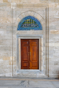 Wooden engraved door on stone wall and tiled marble floor, Sulaymaniye Mosque, Istanbul, Turkey