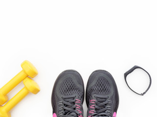 Sports equipment isolated on white background. Running shoes, smart band and dumbbells, top view