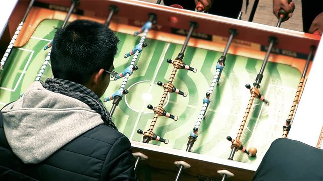 Group of Teenagers Playing the Metegol in La Paz (Bolivia).