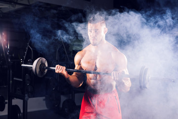 Handsome power athletic man with barbell. Strong bodybuilder with six pack, perfect abs, shoulders,...