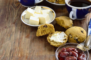 Pumpkin scones with dried fruit for breakfast, served with jam and butter, copy space