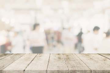 Empty wooden table with blurred abstract people on cafe on restaurant background.