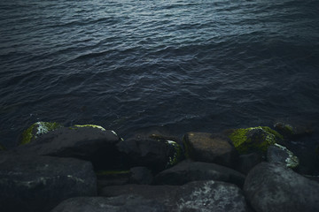 Splashing wave on Stone in sea on sunset time.