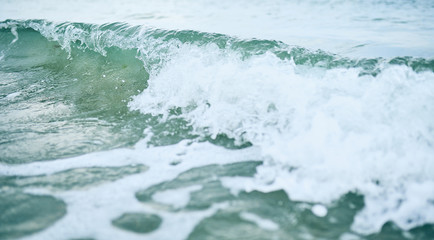 Close-up view of a turquoise sea waves on the beach.