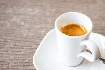Shot of espresso in the white cup close up.