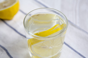 Water with lemon in glass on striped napkin. Diet weight loss and healthy eating. Detox drink.