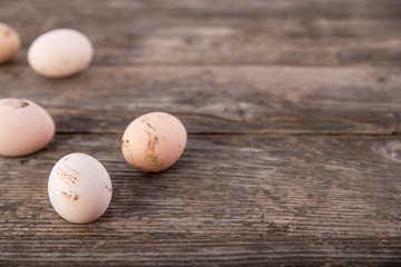 Dirty hen eggs on wooden table, an angle, copy space for text