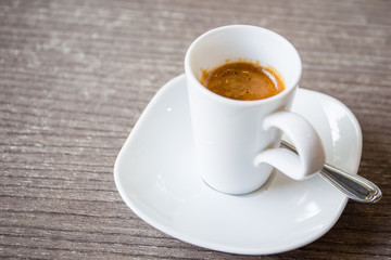 Shot of espresso in the white cup close up.