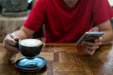 Fototapeta na wymiar Drink hot coffee and play smartphone