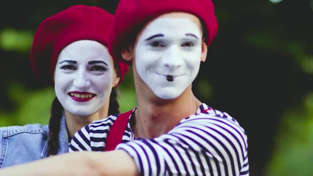 Two mimes push their colleague away