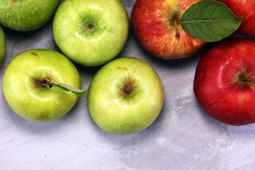 Ripe red apples with leaves on wooden background.