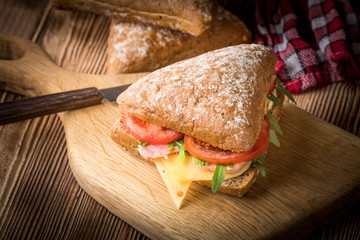 Triangular sandwich with cheese, ham and tomato.