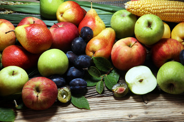 Various fresh fruits. Thanksgiving pumpkin, apples, and maize on rustic background.