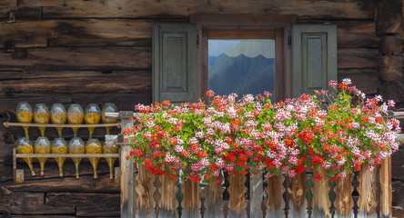 Fototapeta na wymiar Traditional flowered balcony at the Italian Alps and dolomites