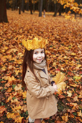 Little Girl Plays In The Autumn Leaves in park