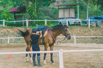 The female trainer is training the young horse for the tame in r