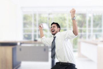 Portrait of working man 20-30 years.Yong businessman stressed and overworked yelling in office.He in white shirt and black plant.Copy space.