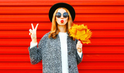 Funny cool girl with red lips and yellow maple leaves on a background
